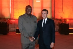 French President Emmanuel Macron shakes hands with Burkina Faso's President Roch Marc Christian Kabore in Lyon, France, Oct. 9, 2019, during the meeting of international lawmakers, health leaders and people affected by HIV, Tuberculosis and malaria.