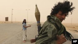 Rebel fighters take up position in the western entrance of Ajdabiyah May 1, 2011.