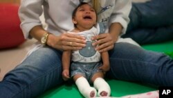 Luana Vitoria, who was born with microcephaly, cries during a physical therapy session at the Altino Ventura Foundation, a treatment center that provides free health care in Recife, Brazil, in this Feb. 4, 2016 photo. (AP Photo/Felipe Dana)