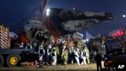 Rescue team carry the body of a passenger at the site of a plane fire at Muan International Airport in Muan, South Korea, Dec. 29, 2024. 
