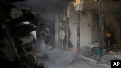 Kashmiri Muslim villagers clean the debris of a house which was damaged in a gunbattle at Shopian, south of Srinagar, Indian controlled Kashmir, Tuesday, Nov. 20, 2018.