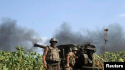 Militer Ukraina berdiri di dekat meriam dalam operasi militer melawan separatis pro-Rusia.