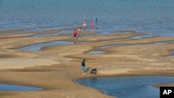 FILE - Sightseers play on a sandbar in the Mekong River in Nakhon Phanom province, northeastern Thailand, Dec. 4, 2019. 