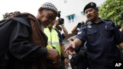 Polisi mengecek identitas seorang pria di Kuala Lumpur, Malaysia. (AP/Lai Seng Sin)