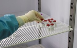 FILE - A medical worker holds a vial of the Oxford-AstraZeneca vaccine against the coronavirus disease (COVID-19) in a mass vaccination center at the Cecchignola military compound, in Rome, Italy, Feb. 23, 2021.