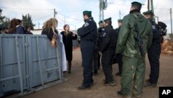 Warga di permukiman Amona di Tepi Barat tengah memberikan keterangan kepada polisi Israel, 1 Februari 2017. Militer telah memerintahkan warga untuk mengosongkan kawasan permukiman ini dalam waktu 48 jam. (AP Photo/Oded Balilty)