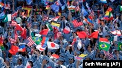 Graduating students from the School of International and Public Affairs at Columbia University wave flags during a graduation ceremony in New York, Wednesday, May 17, 2017.