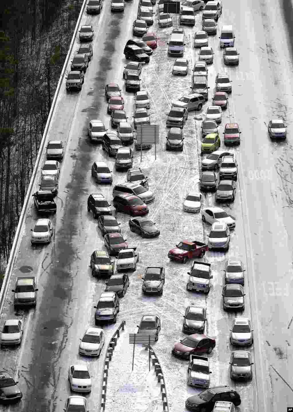 Abandoned cars on I-75 headed northbound near the Chattahoochee River overpass are piled up in the median of the ice-covered interstate after a winter snow storm in Atlanta, Georgia, USA. Georgia Gov. Nathan Deal said that the National Guard was sending military Humvees onto Atlanta&#39;s snarled freeway system in an attempt to move stranded school buses and get food and water to people.