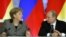 Russian President Vladimir Putin, right, and German Chancellor Angela Merkel speak to each other after a signing ceremony during a Russian-German business forum in the Grand Kremlin Palace in Moscow, Friday, Nov. 16, 2012. 