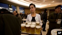 FILE - A North Korean waitress prepares to serve beer at the Mansugyo Soft Drink restaurant in Pyongyang.