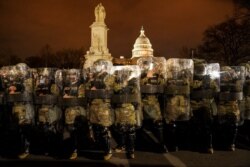 FILE - District of Columbia National Guard troops stand outside the Capitol, Jan. 6, 2021, after a day of rioting protesters.