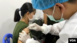 រូបឯកសារ​៖ ស្ត្រី​ម្នាក់ចាក់​វ៉ាក់សាំង​បង្ការ​ជំងឺ​កូវីដ១៩​ ស៊ីណូហ្វាម​​ នៅ​ភ្នំពេញ​ ថ្ងៃ​ទី១០​ ខែ​កុម្ភៈ​ ឆ្នាំ​២០២១​។ (ហ៊ាន សុជាតា​​/វីអូអេ) 