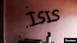 Burned kitchen items are seen in front of a wall spray-painted with the word "ISIS" in a home in the most affected war-torn area of Marawi City, Lanao province, Philippines, May 11, 2019. 