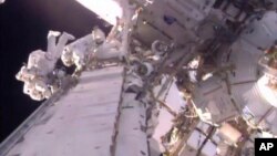 This image taken from video provided by NASA shows U.S. astronaut Shane Kimbrough (L), and French astronaut Thomas Pesquet during a space walk outside the International Space Station, Jan. 13, 2017.