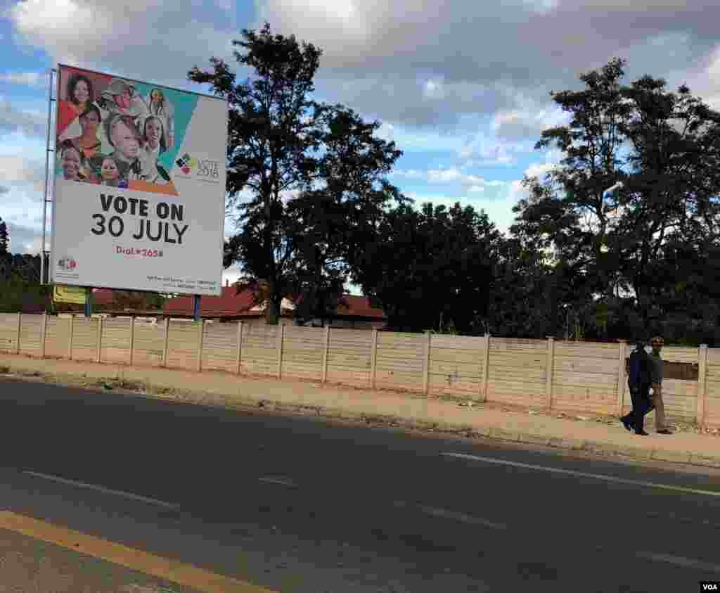 Some police officers walks past a Zimbabwe Electoral Commission poster in Bulawayo where some of them voted in front of their seniors. Opposition says that vote should be nullified and redone, July 20, 2018. (S. Mhofu/VOA)