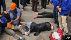 An Indonesian worker attends one of evacuated victims after a structure inside the Jakarta Stock Exchange tower collapsed in Jakarta, Indonesia, Monday, Jan. 15, 2018.