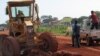 A worker uses heavy machinery as he works on the busy road connecting Kuacjok to Tharkueng in September 2014. Locals welcomed the repairs, which they say are vital to their and other road users' well being. 