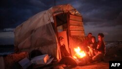 Palestinian children warm up around a fire along the beach in Gaza City on November 22, 2017. (AFP PHOTO / MOHAMMED ABED)