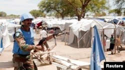 Seorang tentara pasukan penjaga perdamaian PBB berjaga-jaga di luar kamp pengungsi di Bor, Sudan Selatan (29/4). (Reuters/Carl Odera)