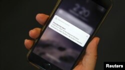 A test text message of the Presidential Alert, National Wireless Emergency Alert System is seen on a mobile phone in New York City, New York, Oct. 3, 2018.