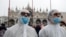 FILE - Tourists wear protective face masks at Venice Carnival, which the last two days of, as well as Sunday night's festivities, have been cancelled because of an outbreak of coronavirus, in Venice, Italy, Feb. 23, 2020. 