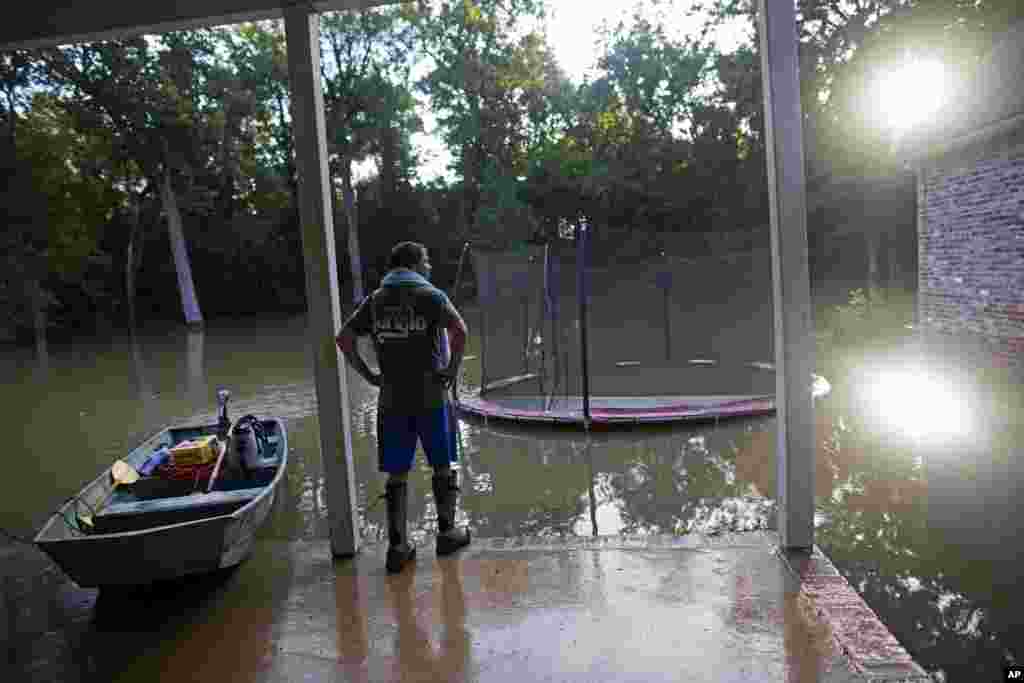 David Key looks at the back yard of his flooded home in Prairieville, La., Aug. 16, 2016. Key, an insurance adjuster, fled his home as the flood water was rising.