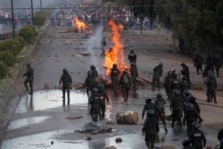 Police dismantle a barricade constructed by supporters of former President Evo Morales, on the outskirts of Cochabamba, Bolivia, Nov. 16, 2019.