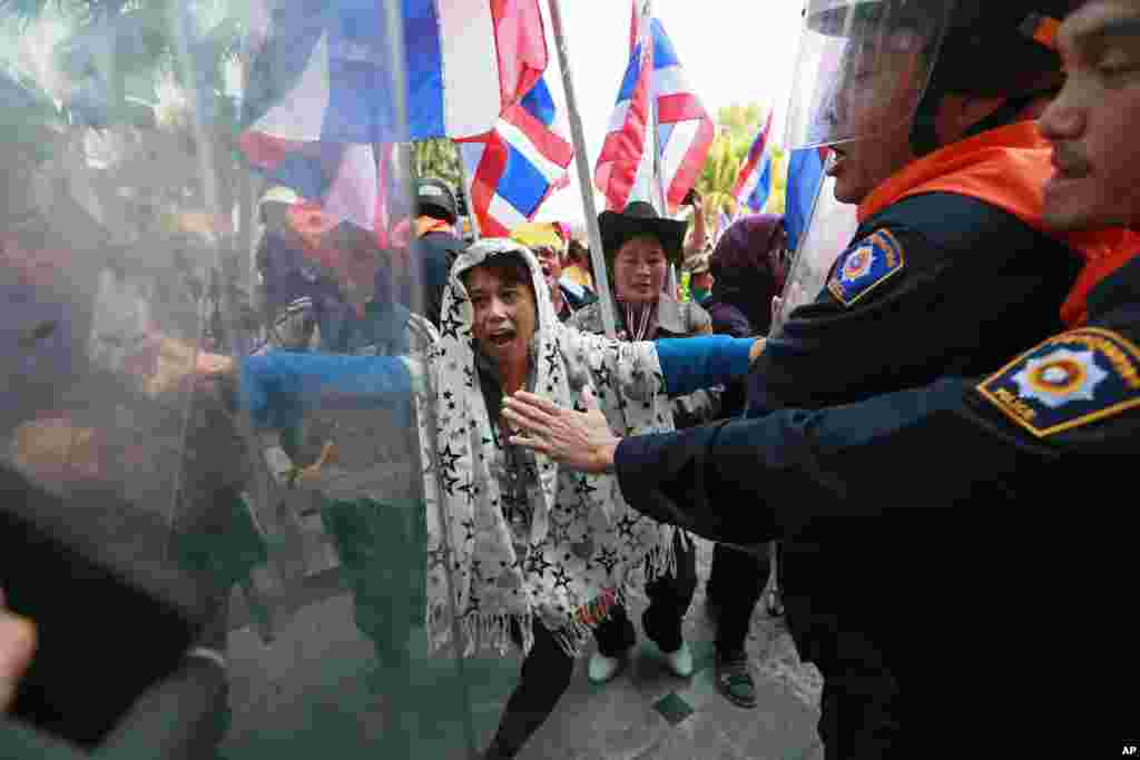 Riot police officers try to stop anti-government protesters from storming an office building during a rally at the Department of Special Investigation on the outskirts of Bangkok, Dec. 23, 2013.