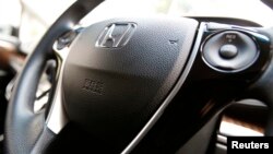The logo of Honda Motor Co and an airbag logo are seen on a steering wheel. REUTERS/Yuya Shino (JAPAN - Tags: TRANSPORT BUSINESS LOGO) - RTR3UACZ