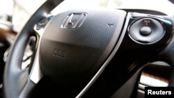 The logo of Honda Motor Co and an airbag logo are seen on a steering wheel of a car displayed at the company's showroom in Tokyo June 17, 2014. REUTERS/Yuya Shino (JAPAN - Tags: TRANSPORT BUSINESS LOGO) - RTR3UACZ