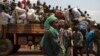 FILE - A woman looks on as people on a truck gather their belongings during a road repatriation to Chad in the capital Bangui, January 22, 2014. 