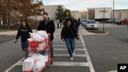 Shoppers walk back to their cars at the Garden State Plaza, in Paramus, New Jersey, Nov. 25, 2017.