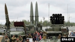 RUSSIA -- Visitors look at Russian tactical ballistic missile OTR-21 Tochka-U (L), 122mm multiple rocket launcher BM-21 Grad (2_L), tactical ballistic missile 9K720 Iskander-M (C) and 300mm multiple rocket launcher BM-30 Smerch (R) during a military exhib