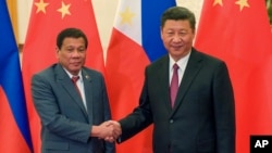 FILE - Philippine President Rodrigo Duterte, left, and Chinese President Xi Jinping pose for photographers on the sidelines of the Belt and Road Forum for International Cooperation at the Great Hall of the People in Beijing, May 15, 2017. 