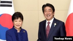 박근혜 한국 대통령(왼쪽)과 아베 신조 일본 총리가 7일 라오스 비엔티안 국립컨벤션센터(NCC)에서 열린 정상회담에서 악수하고 있다.