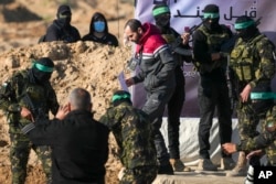 Izraelca Yardena Bibasa, 34, kojeg Hamas drži kao taoca u Gazi od 7. oktobra 2023. godine, prate Hamasovi borci prije nego što je predat Crvenom križu u Khan Younisu, južni pojas Gaze, 1. februara 2025. godine.