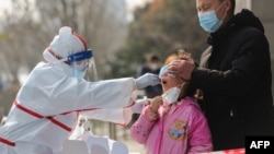 中国武汉的医务人员在给一个女孩进行核酸检测。（2020年3月5日）