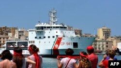 Anggota gerakan T-shirt merah menunggu kedatangan kapal penjaga pantai Diciotti Italia yang membawa 67 pencari suaka, di pelabuhan Trapani, 12 Juli 2018. (Foto: dok).