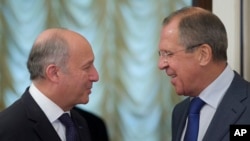 Menlu Rusia Sergei Lavrov (kanan) menyambut kedatangan Menlu Perancis Laurent Fabius sebelum berlangsungnya pertemuan terkait Suriah di Moskow (17/9). 