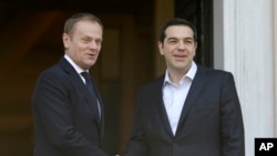 PM Yunani Alexis Tsipras (kanan) berpose dengan Presiden Dewan Eropa Donald Tusk sebelum melangsungkan pembicaraan di Maximos Mansion, Athena, Yunani (3/3).
