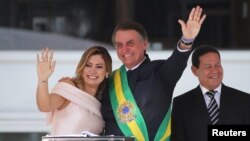 Presiden Brazil, Jair Bolsonaro didampingi ibu negara, Michelle Bolsonaro, di Istana Planalto usai pelantikan di Brasilia, Brazil, 1 Januari 2019.