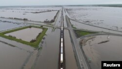 A train passes as floodwaters from the Tule River inundate the area after days of heavy rain in Corcoran, California, U.S. on March 22, 2023. (REUTERS/David Swanson)
