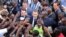 French President Emmanuel Macron (C) meets residents as he leaves the Ouagadougou University after giving a speech, Nov. 28, 2017, in Ouagadougou, as part of his first African tour since taking office.