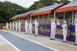 Policemen wearing personal protective equipment guard seized illegal drugs before burning them during a destruction ceremony to mark International Day Against Drug Abuse and Illicit Trafficking outside Yangon, Myanmar, June 26, 2020.
