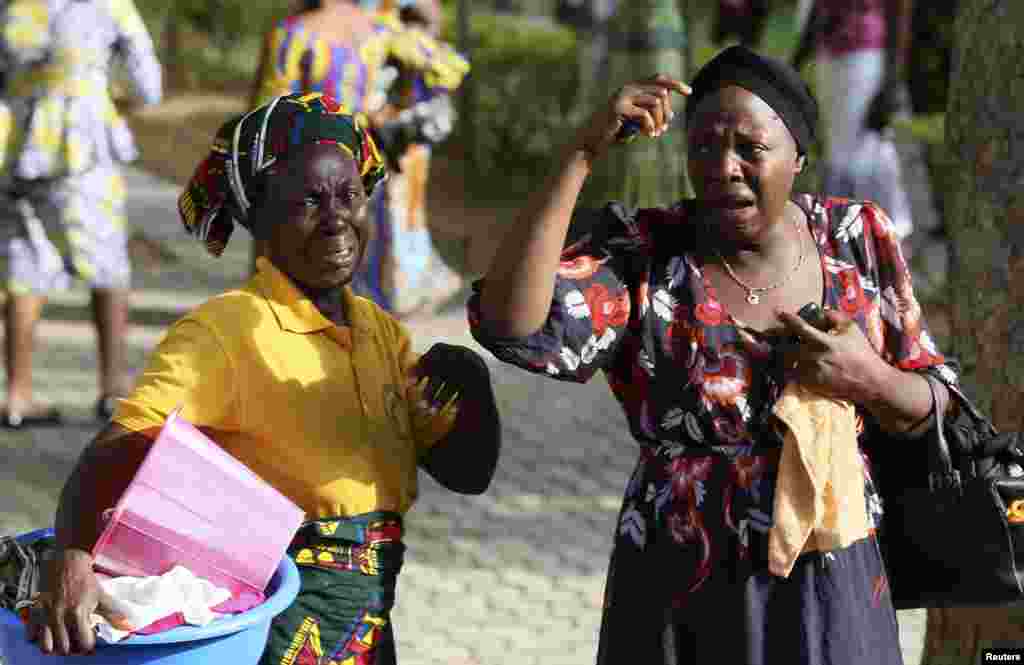 Bystanders react as victims of a bomb blast arrive at the Asokoro General Hospital in Abuja, April 14, 2014.