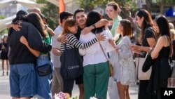 ຄົນກຸ່ມນຶ່ງ ສະແດງປະຕິກິລິຍາ ຫຼັງຈາກທີ່ໄດ້ວາງດອກໄມ້ ໄວ້ອາໄລ ຢູ່ໃກ້ສະຖານທີ່ເກີດເຫດ ຢູ່ແຍກ ບອນໄດ (Bondi Junction) ໃນນະຄອນຊິດນີ, ວັນທີ 15 ເມສາ 2024, ຫຼັງຈາກມີຫຼາຍຄົນຖືກແທງເສຍຊີວິດ ຢູ່ສູນການຄ້າແຫ່ງນຶ່ງ ໃນວັນທີ 13 ເມສາທີ່ຜ່ານມາ. 