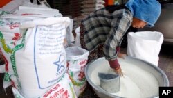 រូបឯកសារ៖ អាជីករម្នាក់កំពុងរើសសំបកស្រូវតូចៗចេញពីអង្ករ នៅតូបលក់អង្ករមួយកន្លែង នៅរាជធានីភ្នំពេញ ថ្ងៃទី១៧ ខែមេសា ឆ្នាំ២០១៩។ 