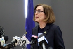 FILE - Oregon Gov. Kate Brown speaks at a news conference in Portland, Oregon, March 16, 2020.