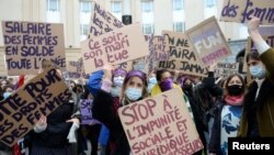 FILE - Women hold placards during a demonstration to call for gender equality and demand an end to violence against women, on International Women's Day in Brussels, Belgium, March 8, 2021. 