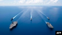 Kapal induk pembawa jet tempur AS, USS Ronald Reagan dan kapal penyerang amfibi USS Boxer saat melakukan operasi keamanan dan stabilitas di wilayah operasi Armada ke-7 AS, di Laut China Selatan, 6 Oktober 2019. (Foto: AFP)